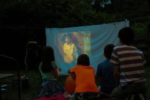 1 kids watching a movie outside