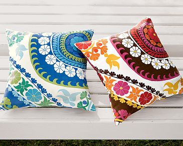 two multicolored pillows that you can place on a bench