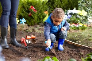 1 child playing with tiny shovel in the dirt