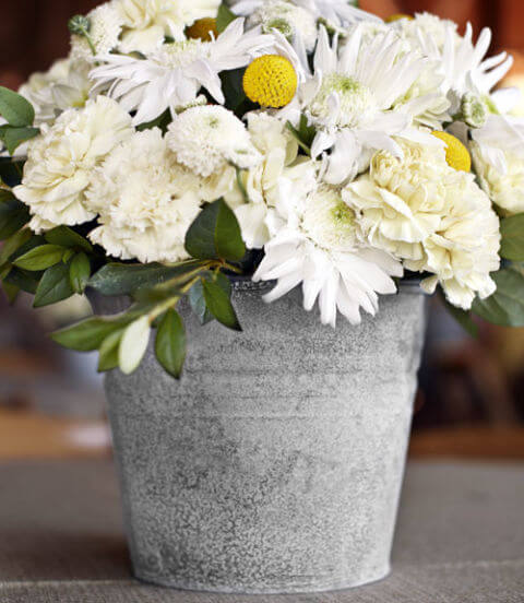 white flower placed in a vintage bucket