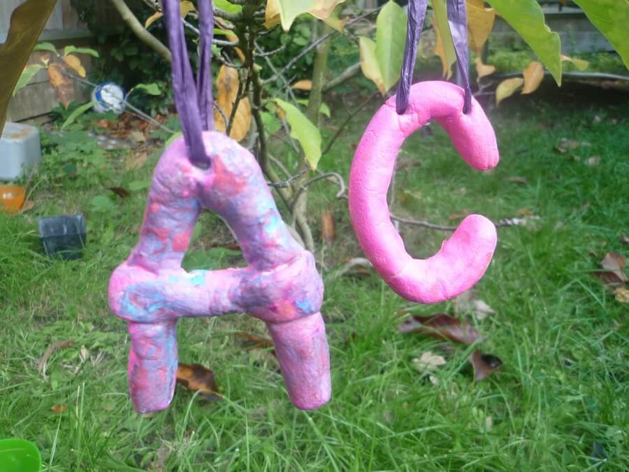 pink letter made of dough hanging in trees