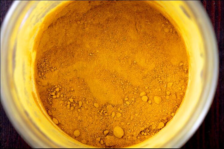 Pot with turmeric powder seen from above