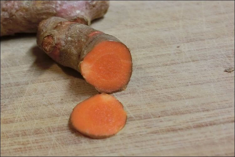 Turmeric root with a slice of it next to it