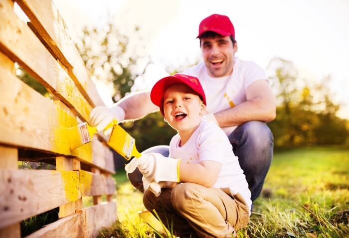 father and son painting fence